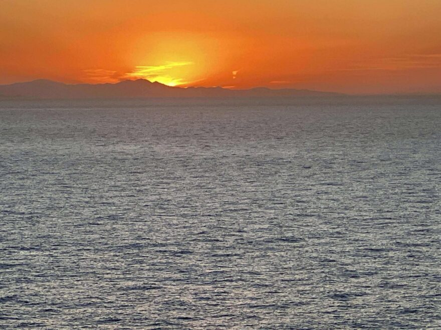 A sunset over the ocean with orange sky